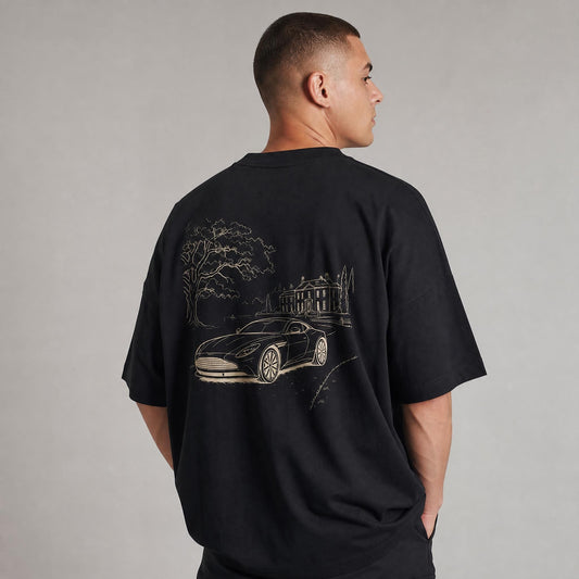 Rücken des schwarzen Landgut Oversized T-Shirts von CLUTCHO: große Champagner-Line-Art eines britischen Grand Tourer vor einem englischen Landgut.