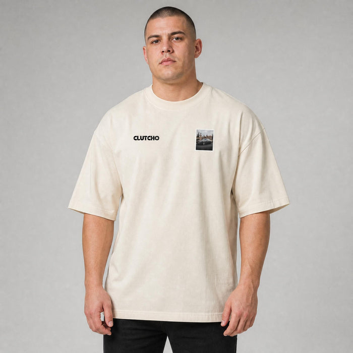 Beiges CLUTCHO Herrenhaus Oversized T-Shirt Herren, Front-Briefmarke mit britischer Luxuslimousine vor einem Herrenhaus-Tor.