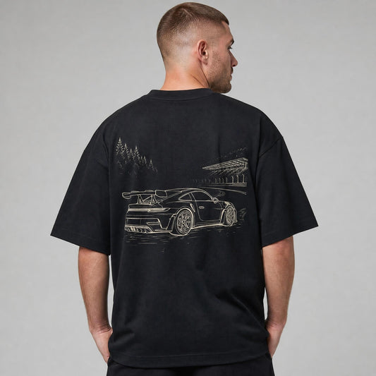Rücken des schwarzen Nürburgring Oversized T-Shirts von CLUTCHO: große Champagner-Line-Art eines deutschen Sportwagens auf der Nordschleife.