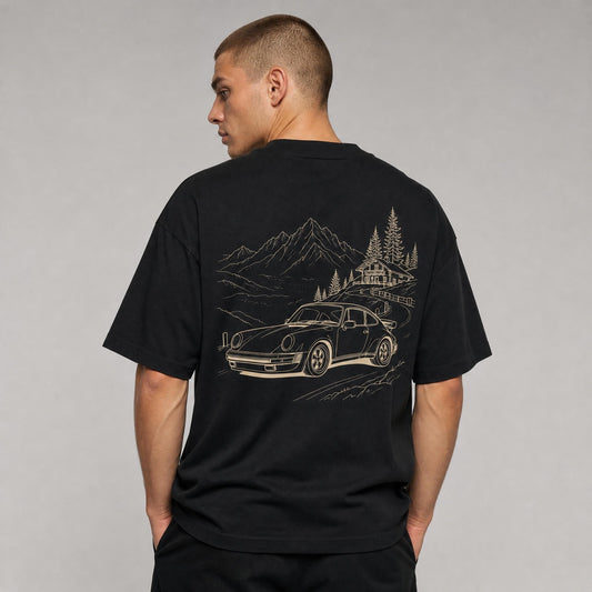 Rücken des schwarzen Alpenpass Oversized T-Shirts von CLUTCHO: große Champagner-Line-Art eines klassischen Heckmotor-Sportwagens auf einem Alpenpass.