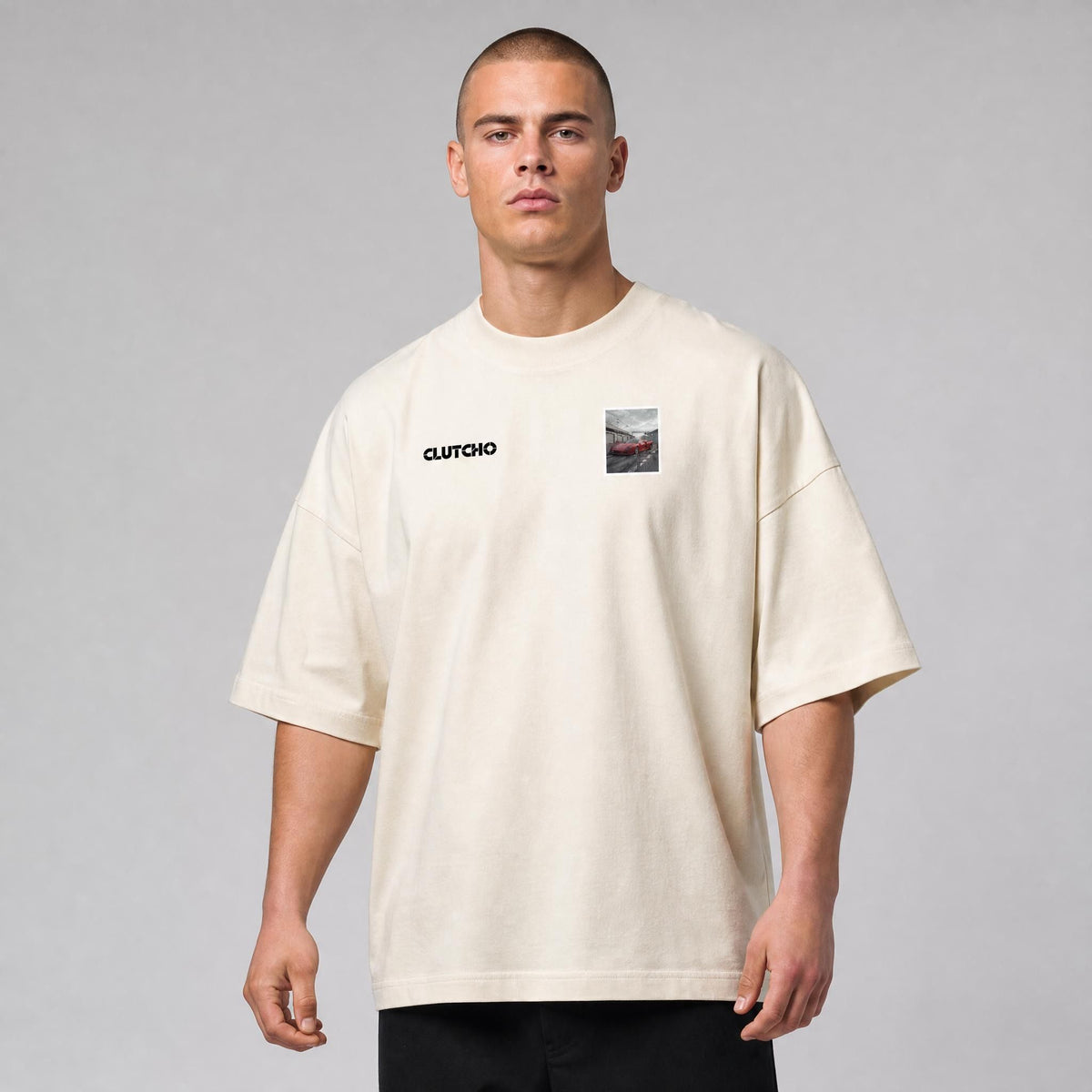 Beiges CLUTCHO Boxengasse Oversized T-Shirt Herren, Front-Briefmarke mit italienischem 80er-Supersportwagen in der Boxengasse.