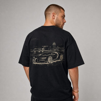 Rücken des schwarzen Jetset Oversized T-Shirts von CLUTCHO: große Champagner-Line-Art eines Hypercars am Privatflughafen.