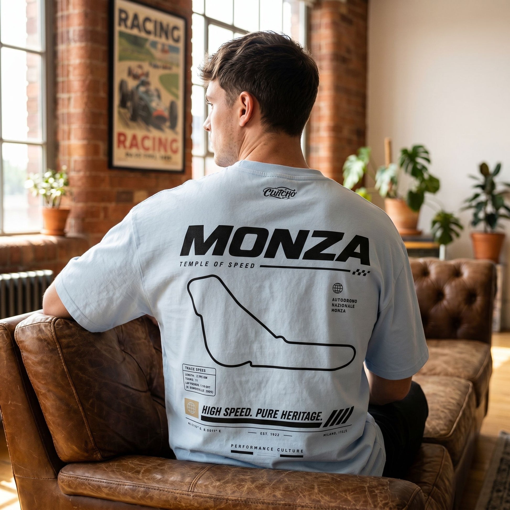 Model seated on a leather sofa wearing the shirt, showcasing the Monza print and high-quality fabric in a casual setting.