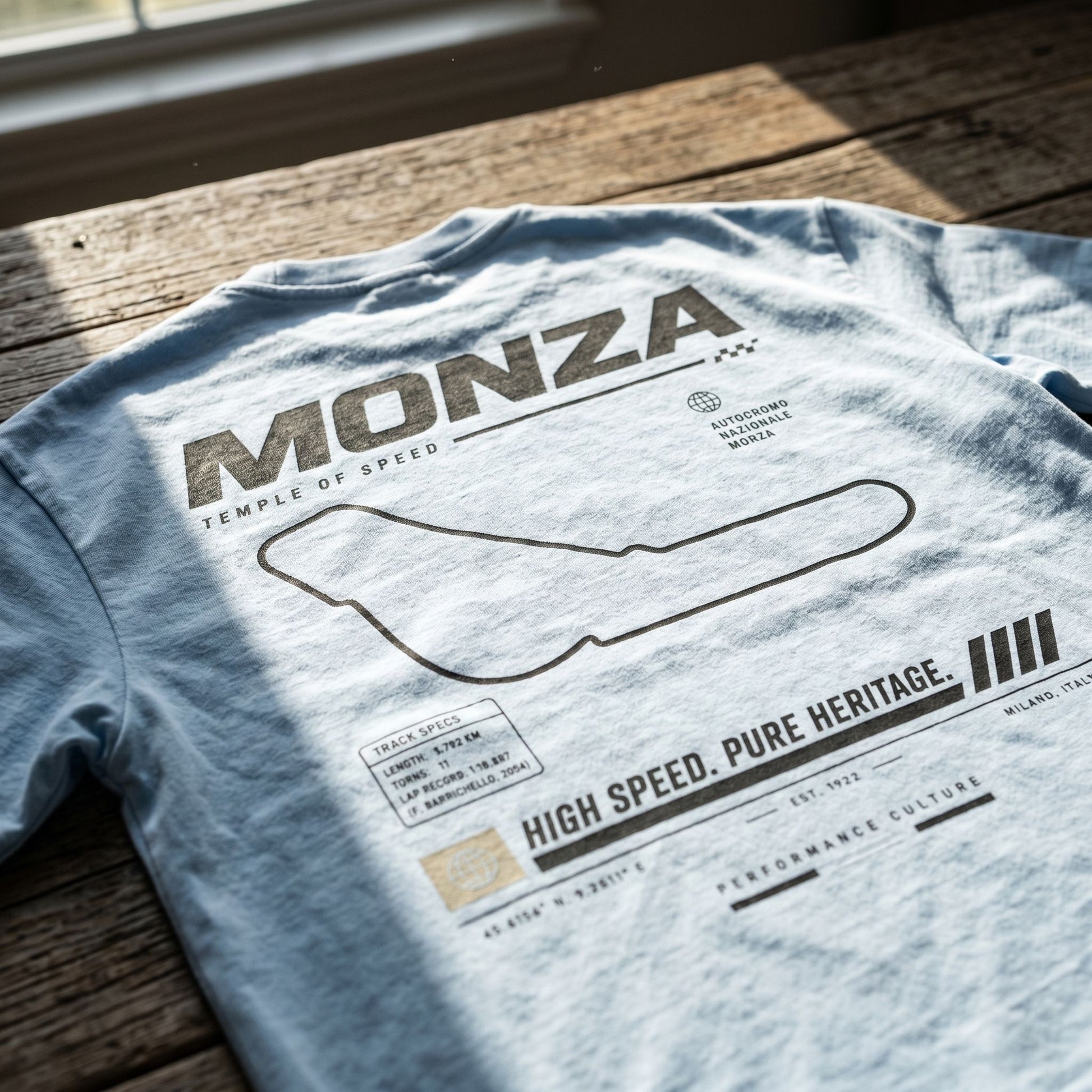 Close-up of the shirt laid flat, focusing on the fabric’s weight, Monza print, and detailed design on rustic wood.