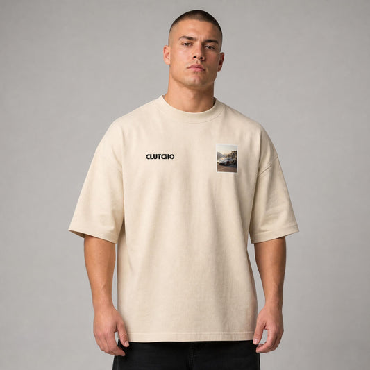 Beiges CLUTCHO Fjord Oversized T-Shirt Herren, Front-Briefmarke mit Hypercar an einem nordischen Fjord.
