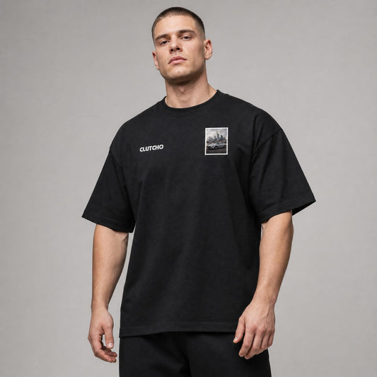 Schwarzes CLUTCHO Frankfurt Skyline Oversized T-Shirt Herren, Front-Briefmarke mit deutschem Sportwagen vor der Frankfurter Skyline.