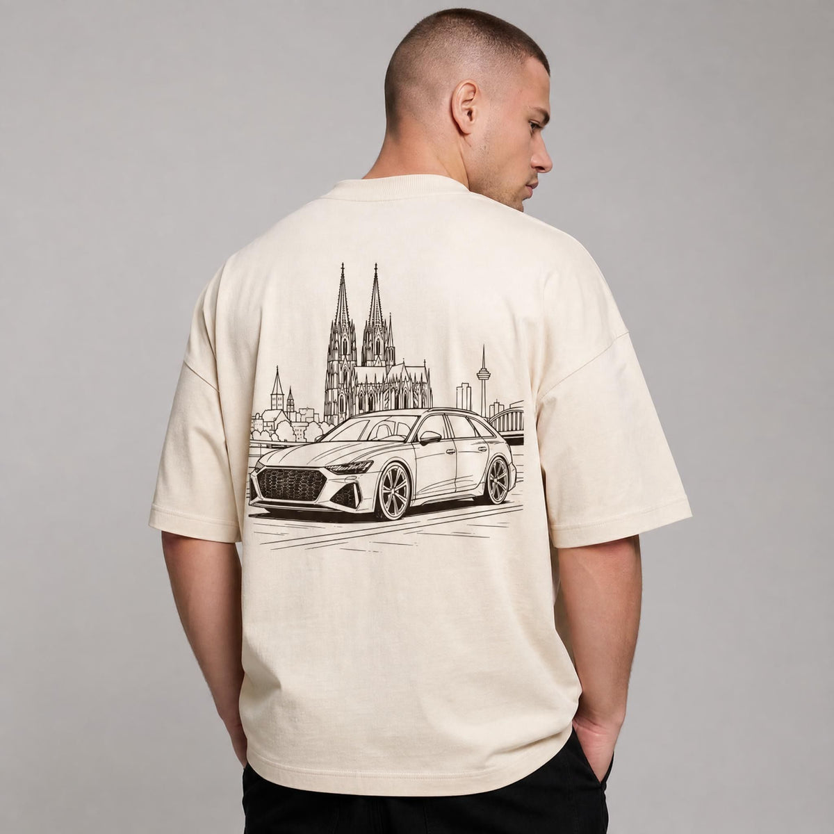 Rücken des beigen Kölner Dom Oversized T-Shirts von CLUTCHO: große Espresso-Line-Art mit Kölner Dom und deutschem Performance-Kombi.