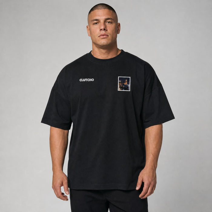 Schwarzes CLUTCHO London Vibes Oversized T-Shirt Herren, Front-Briefmarke mit britischem Supersportwagen vor der London-Skyline auf der Brust.