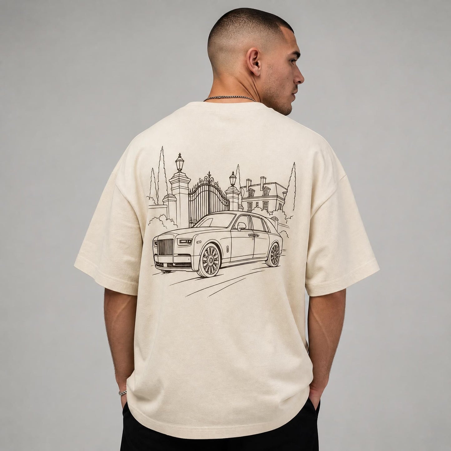 Rücken des beigen Herrenhaus Oversized T-Shirts von CLUTCHO: große Espresso-Line-Art einer britischen Luxuslimousine vor einem Herrenhaus.