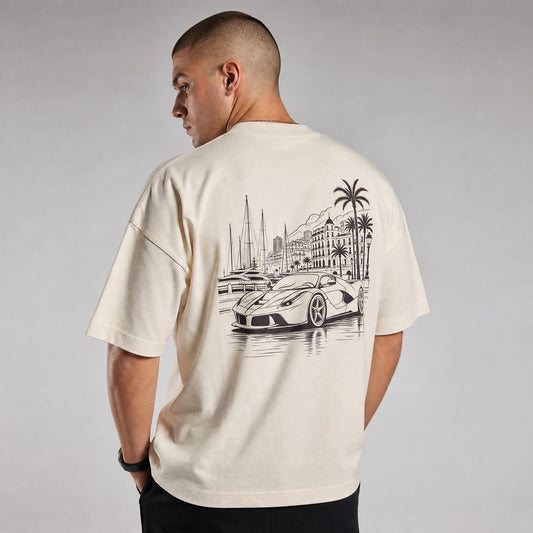 Rücken des beigen Monaco Vibes Oversized T-Shirts von CLUTCHO: große Espresso-Line-Art eines italienischen Supersportwagens an der Monaco-Hafenpromenade.
