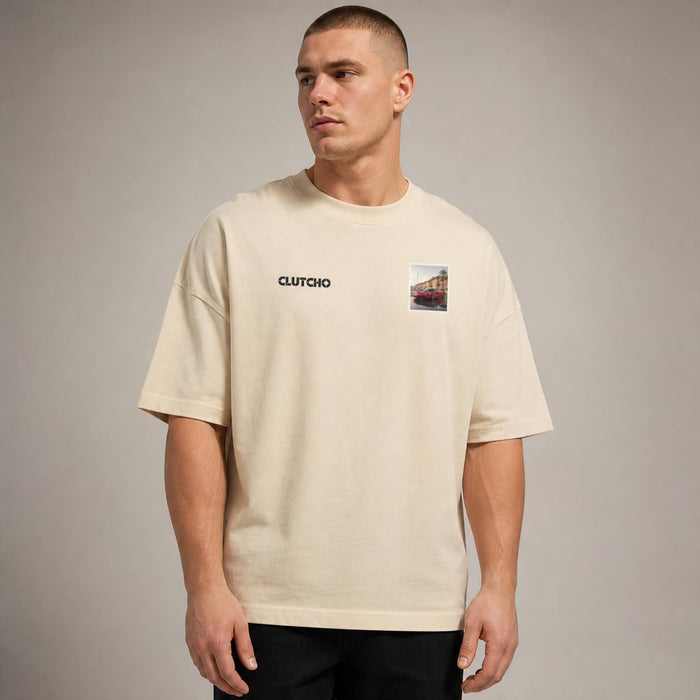 Beiges CLUTCHO Monaco Vibes Oversized T-Shirt Herren, Front-Briefmarke mit italienischem Supersportwagen an der Hafenpromenade von Monaco.