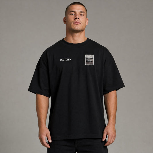 Schwarzes CLUTCHO Nürburgring Oversized T-Shirt Herren, Front-Briefmarke mit deutschem Sportwagen auf der Nordschleife.