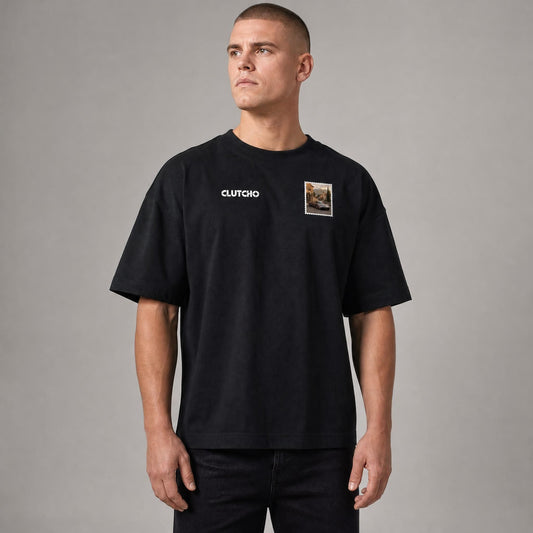 Schwarzes CLUTCHO Toskana Vibes Oversized T-Shirt Herren, Front-Briefmarke mit italienischem Supersportwagen auf einer Toskana-Landstraße.